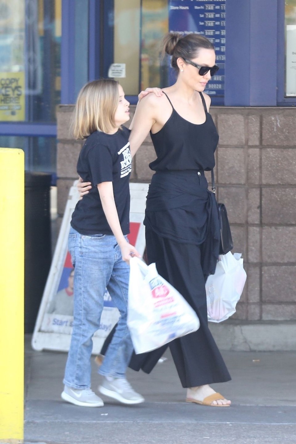Анджелина Джоли в черных брюках и шлепанцах