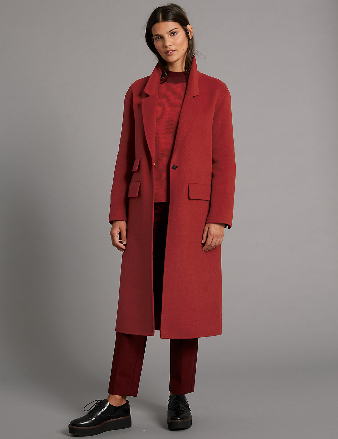 Модель в красном пальто на одной пуговице